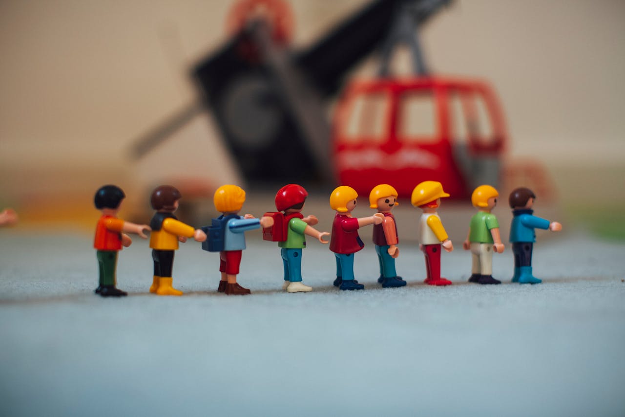 About Miniature plastic figures lined up in front of a toy helicopter, creating a playful scene.